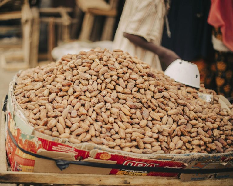 Large pile of cocoa beans on a vendor stand in a market, ready for trade.
